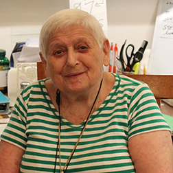 Anne smiling and wearing a green and white striped shirt. 