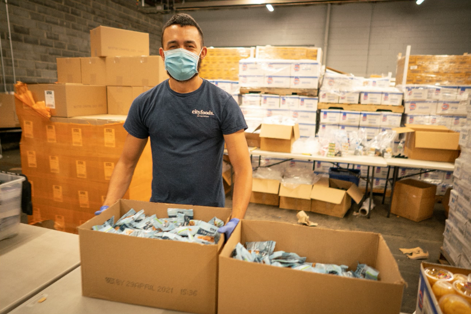 Citymeals staffer packing meals at our warehouse in the Bronx. 