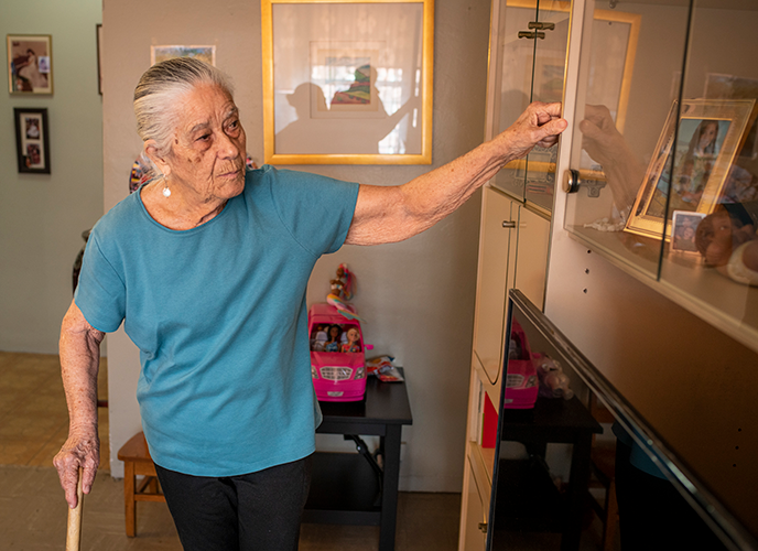 Vicenta at home surrounded by family photos and her grandaughter's toys. 